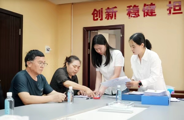 明月山担保公司工作人员（右）正在为客户办理业务。向成国摄